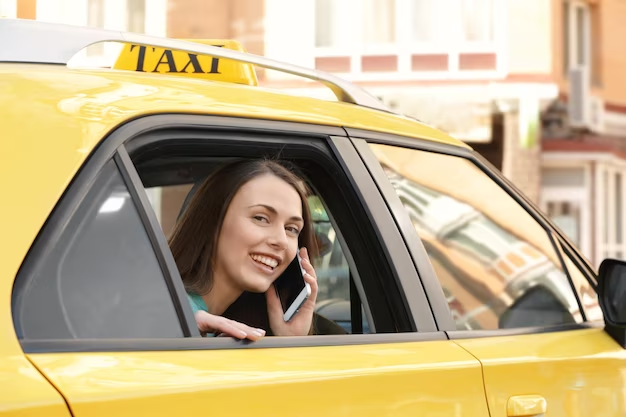 Woman chatting on phone while inside a yellow taxi
