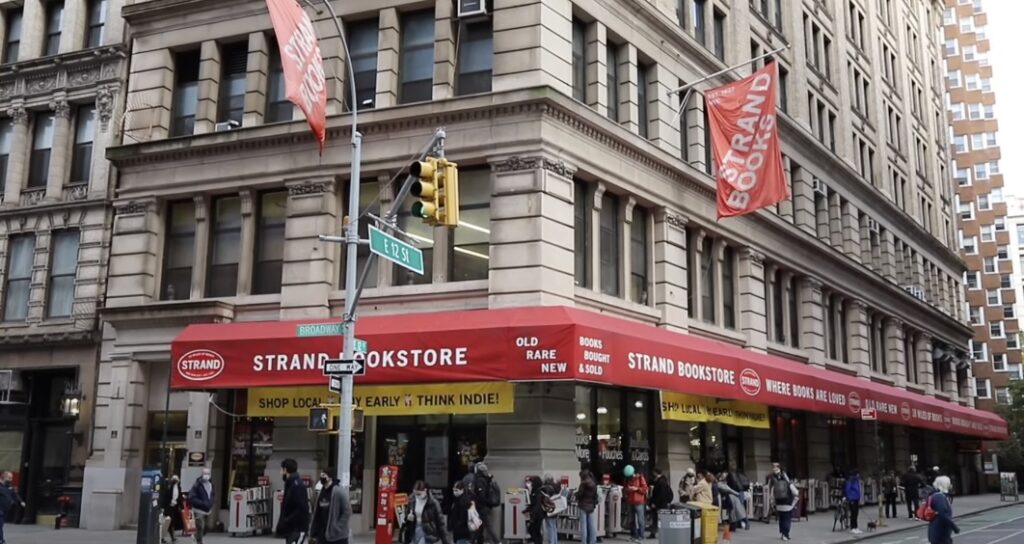 Exterior view of The Strand Bookstore on a corner street with people walking outside.