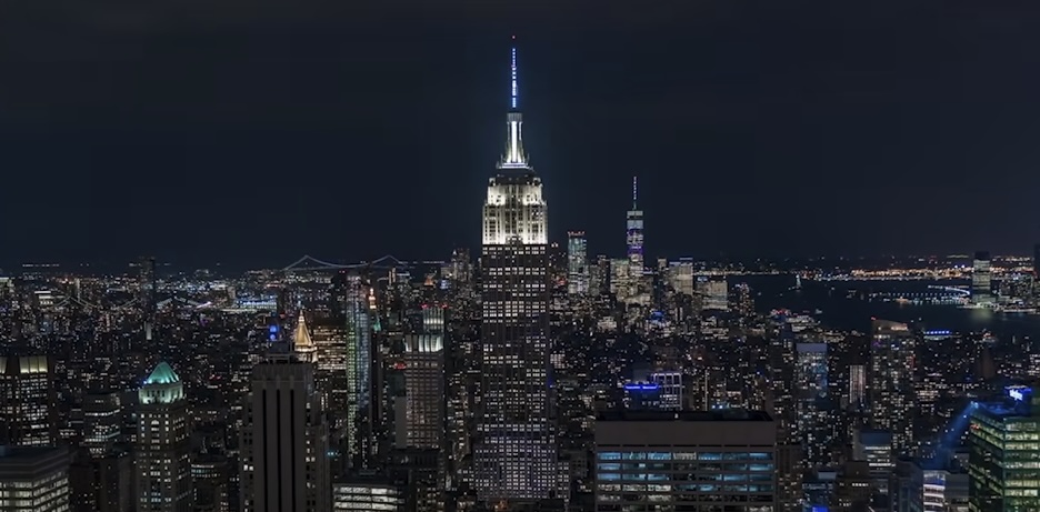 Aerial view of the city with the brightly lit Empire State Building at night